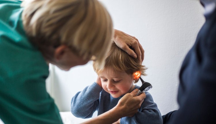 KNO-arts kijkt bij kindje in het oor