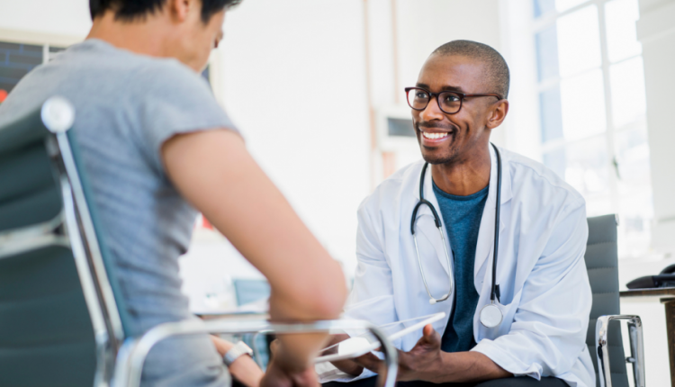 Een glimlachende dokter zit tegenover een man