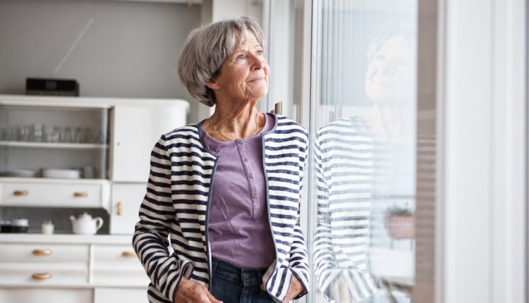 Vrouw kijkt thuis uit het raam