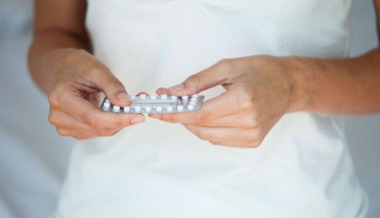 Vrouw met strip anticonceptiepillen in handen