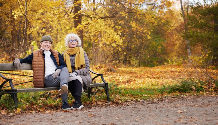 senior stel op bank in het park in de herfst