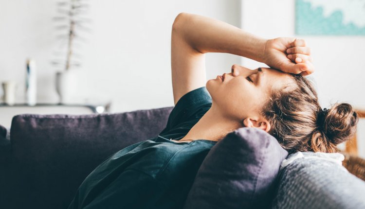 Vrouw met hoofdpijn op de bank