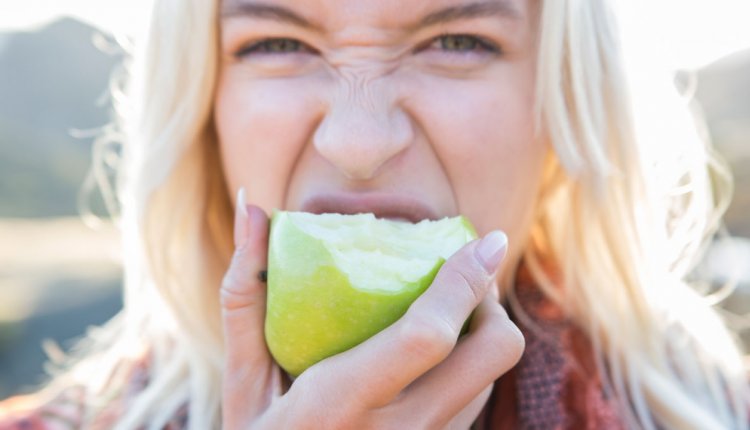 blonde vrouw neem een hap van een appel