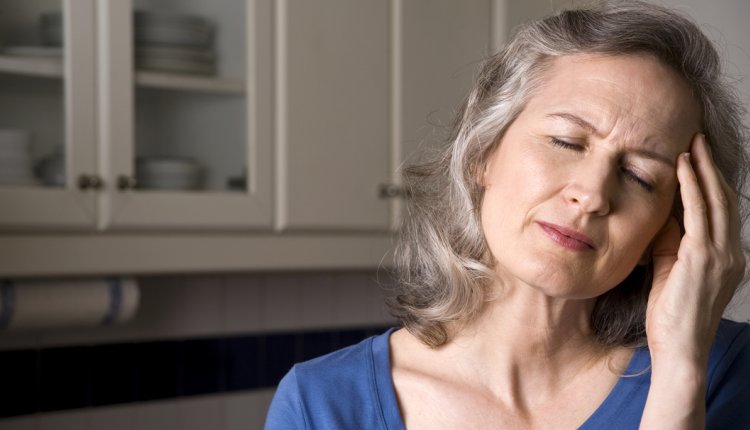 oudere vrouw grijpt naar hoofd