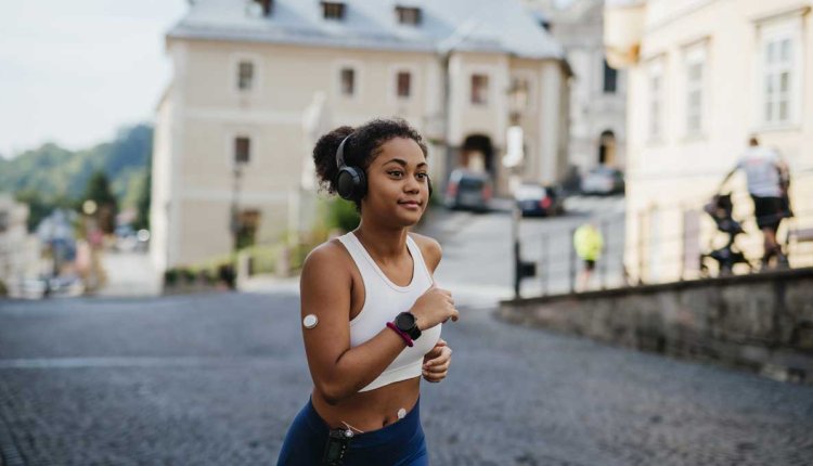 vrouw met glucosesensor en insulinepomp doet aan hardlopen