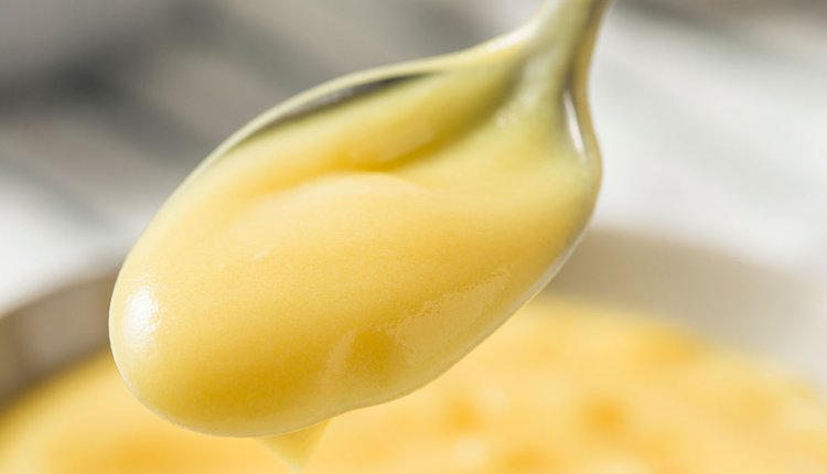 Een schaaltje vanille vla met een lepel erin