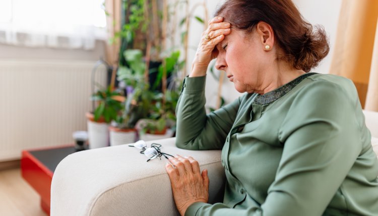 Vrouw zit op bank omdat ze duizelig is