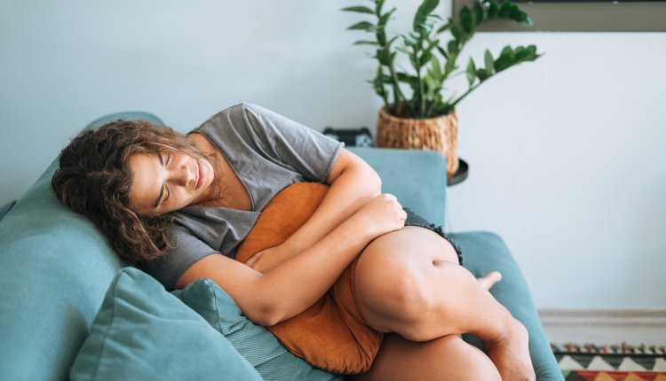 Vrouw voelt zich niet prettig, zit gedeprimeerd op de bank