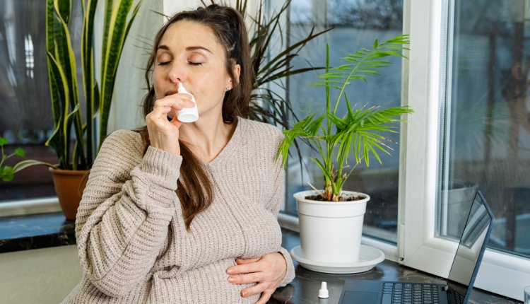 zwangere vrouw gebruikt neusspray