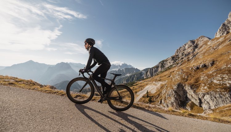 Man beklimt op de racefiets een berg 