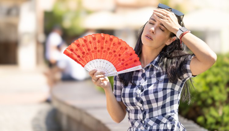 Vrouw met waaier om af te koelen
