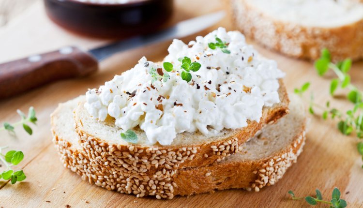 Een boterham op een houten plank met hüttenkäse