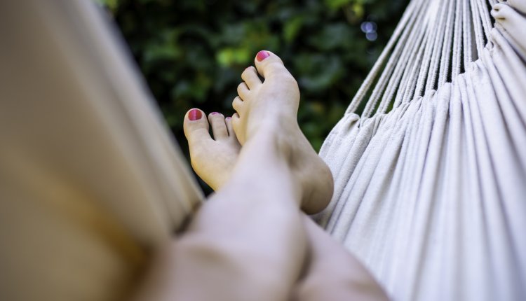 Vrouw in hangmat met de benen omhoog