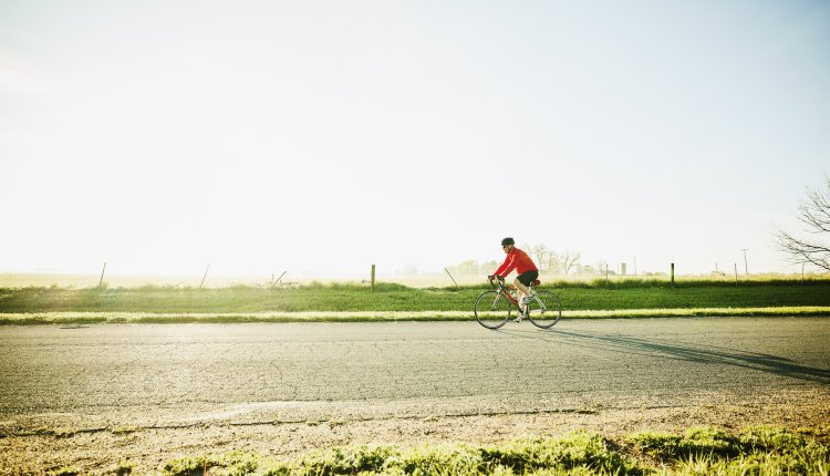 Man fietst door de polder op een zonnige morgen