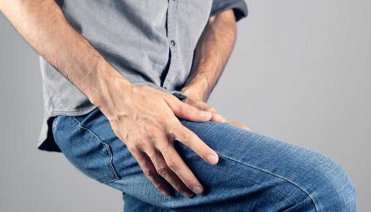 Man wrijft over zijn pijnlijke, doof voelende bovenbeen