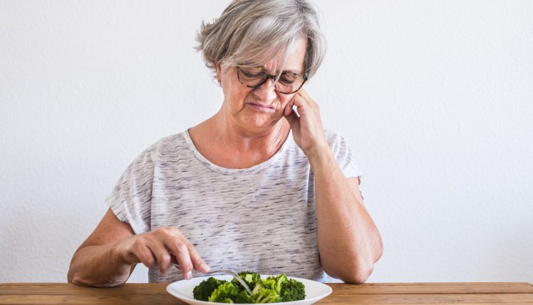 vrouw eet met tegenzin
