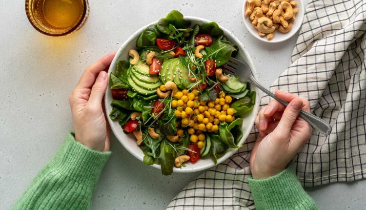 Vrouw eet salade met peulvruchten