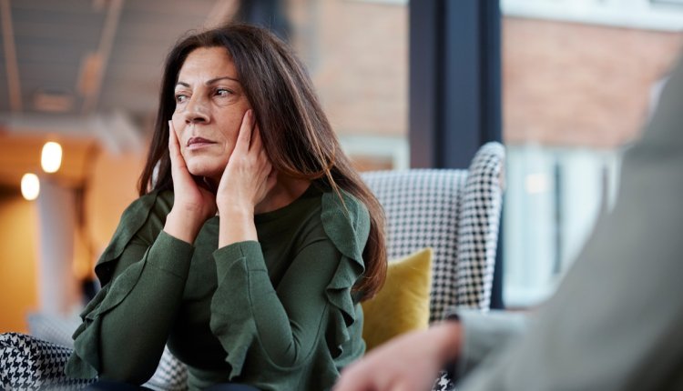 Vrouw met handen op haar oren 