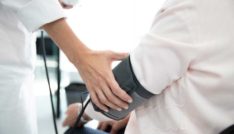 Bloeddruk wordt opgemeten bij een persoon die zit