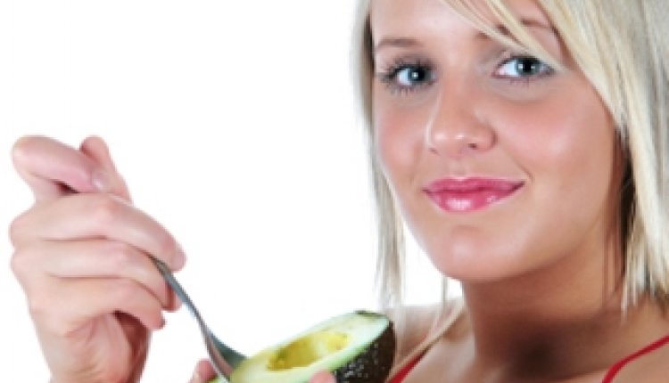 Vrouw eet avocado