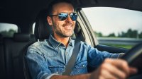 Man met zonnebril op achter het stuur van een auto