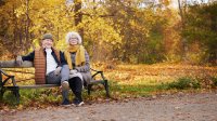 senior stel op bank in het park in de herfst