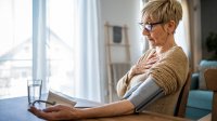 Vrouw meet thuis haar bloeddruk met bloeddrukmeter