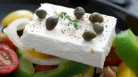 Stuk feta op een Griekse salade met olijven