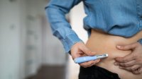 Vrouw spuit afslankmedicatie in haar buik om af te vallen