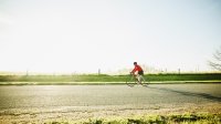 Man fietst door de polder op een zonnige morgen