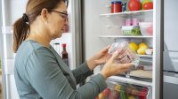 Vrouw checkt houdbaarheidsdatum van verpakking