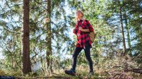 Vrouw loopt ontspannen door de bossen in het herfstzonnetje