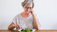vrouw eet met tegenzin