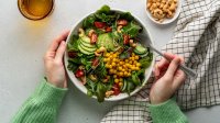Vrouw eet salade met peulvruchten