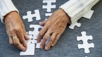 oudere vrouw met dementie puzzelt