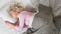 Vrouw ligt heerlijk te slapen in bed