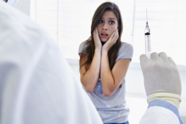 Vrouw met prikangst bij een arts voor het halen van een vaccin