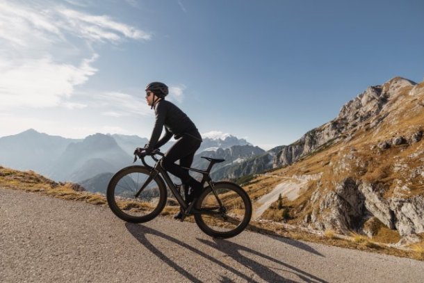 Man beklimt op de racefiets een berg 