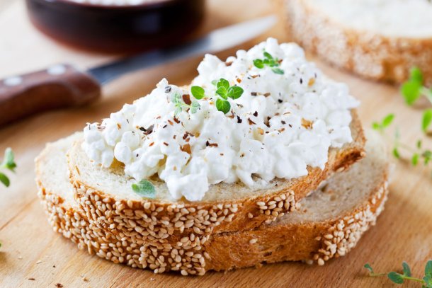 Een boterham op een houten plank met hüttenkäse