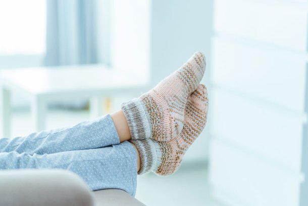 Vrouw op de bank met voeten in warme dikke sokken