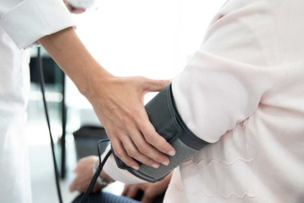 Bloeddruk wordt opgemeten bij een persoon die zit