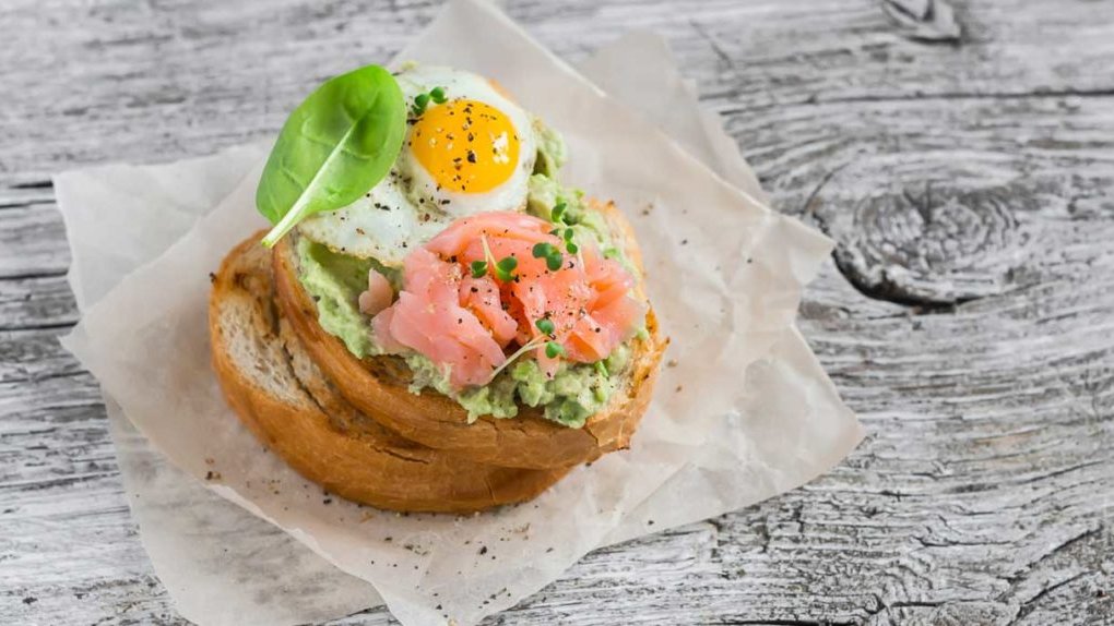 Bruine bol met avocado, zalm en een eitje