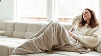 Vrouw met menstruatieklachten op de bank