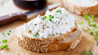 Een boterham op een houten plank met hüttenkäse