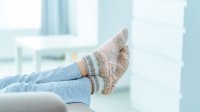 Vrouw op de bank met voeten in warme dikke sokken