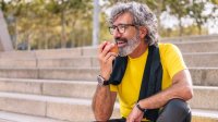 Sportende man neemt pauze en appel