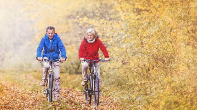 Senior stel fietst in de herfst