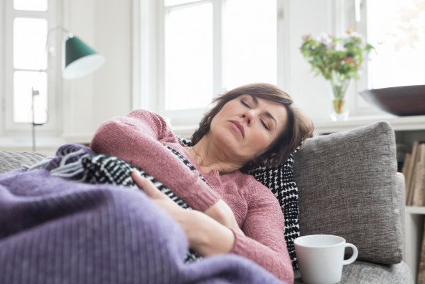 Vrouw met buikpijn op de bank