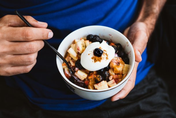 Man eet havermout met fruit