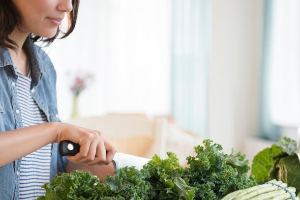 Vrouw snijdt boerenkool om stamppot van te maken